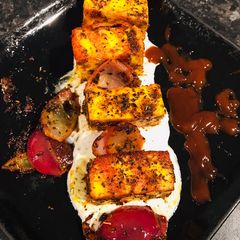 A picture of Basil Paneer Tikka Masala and mint yoghurt.