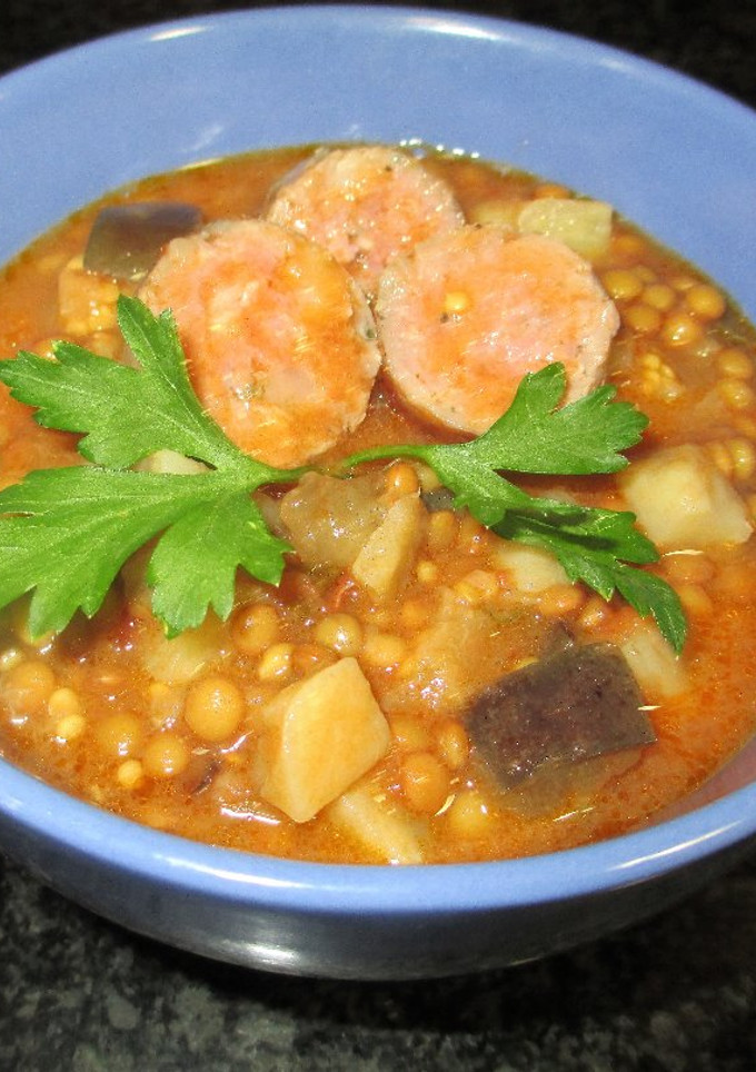 Una foto de Lentejas pardina con salchichas, apio nabo y berenjena