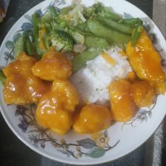 A picture of Orange Chicken Asian Veggies Over Rice.
