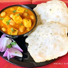 A picture of Chana Paneer with Kasoori methi flavoured Bhaturas.