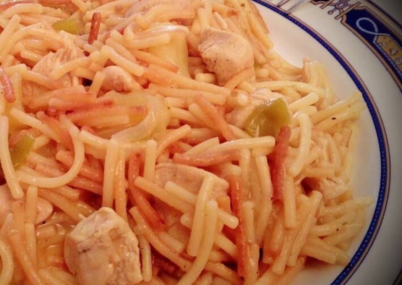 Fideos dorados con pechuga de pollo en trozos