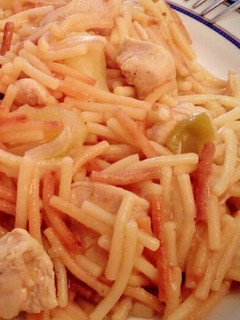 Una foto de Fideos dorados con pechuga de pollo en trozos