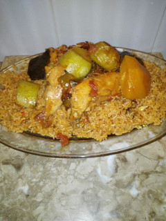 Una foto de Arroz con pollo y salsa de tomate y verduras