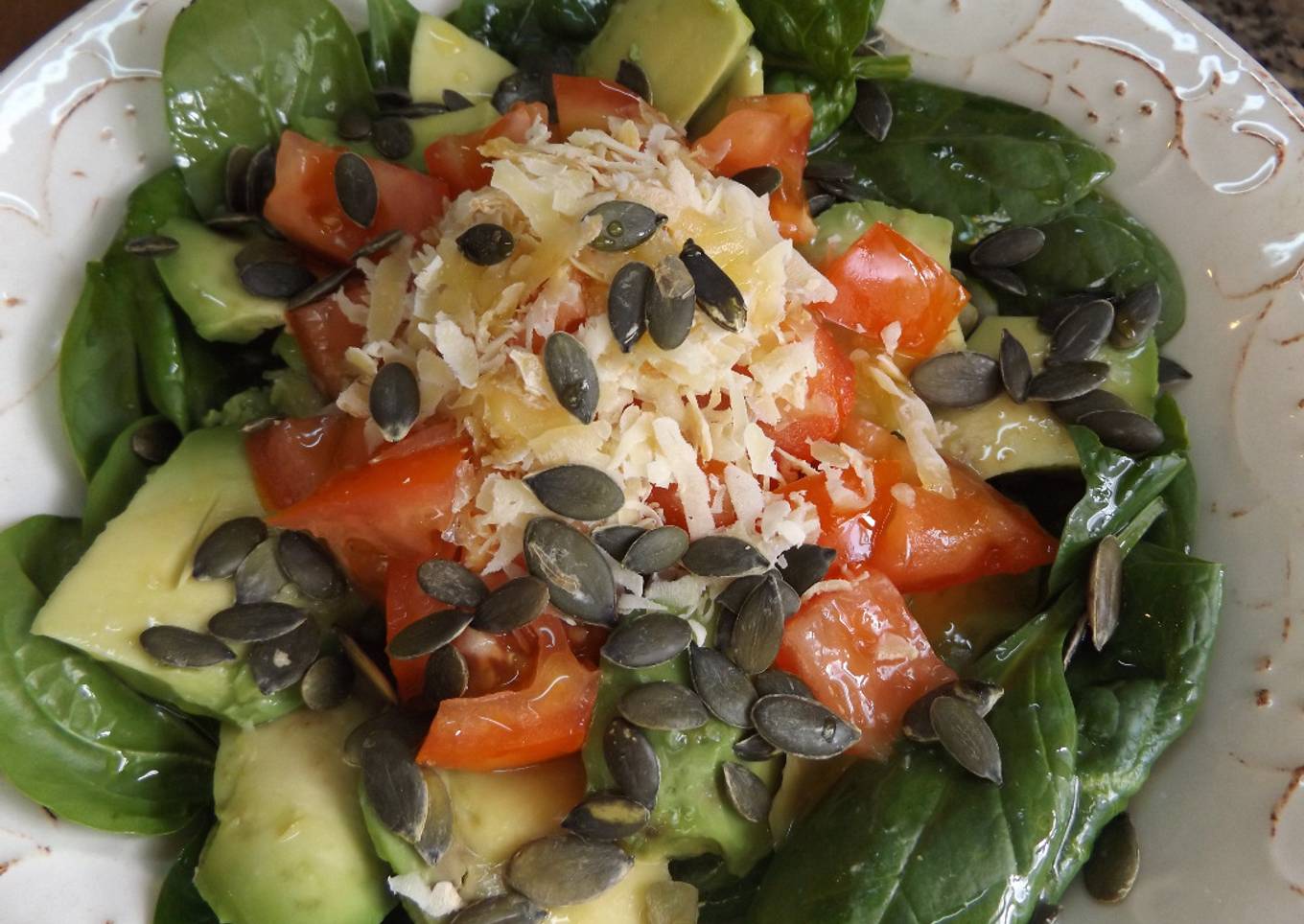 Ensalada simple de hojas de espinacas crudas con aguacate, pepino y tomates