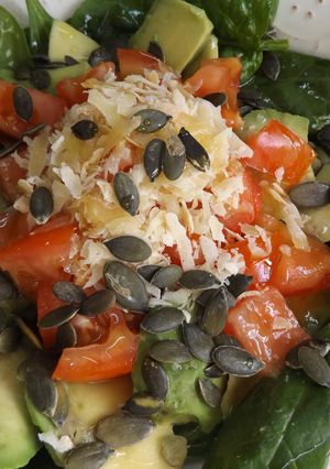 Foto principal de Ensalada simple de hojas de espinacas crudas con aguacate, pepino y tomates