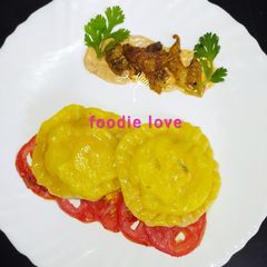 A picture of Carrot infused chicken ricotta ravioli with baked tomato sauce.