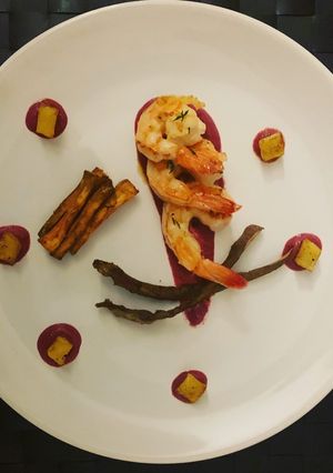 Foto di Gamberi scottati su crema di barbabietola, patate a cubetti e patate dolci al forno e chips di bucce