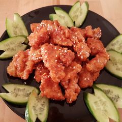 A picture of Breast chicken popcorn with a glaze of honey ranch sauce.