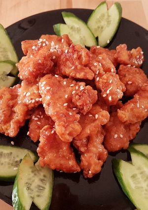 A picture of Breast chicken popcorn with a glaze of honey ranch sauce.