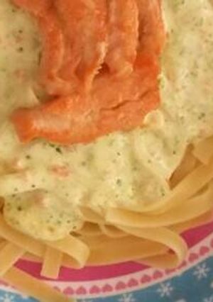 A picture of Brocolli and carrot cream with fetuccini and salmon.