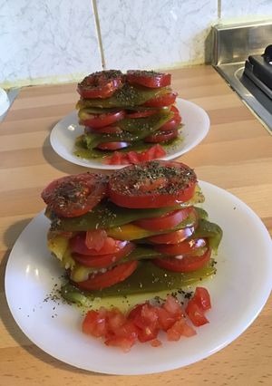 Une photo de Mille feuille de poivrons grillés aux tomates ail et huile d olive et basilic