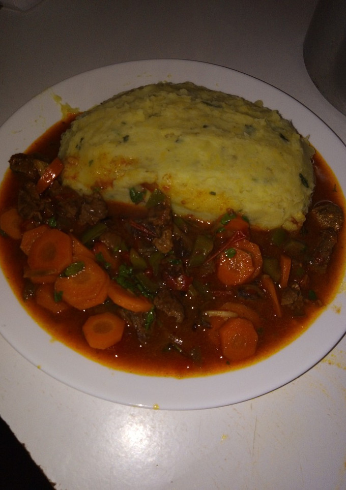 A picture of Mashed potatoes with beef stew.