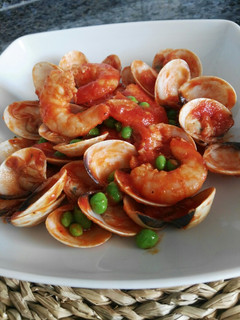 Una foto de Almejas y langostinos con guisantes en salsa picante