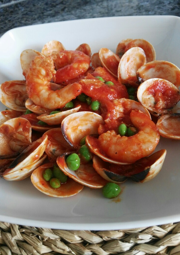 Una foto de Almejas y langostinos con guisantes en salsa picante