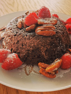 Una foto de Bizcocho keto de chocolate con pecanas y frambuesas