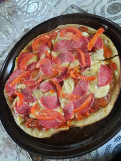 Una foto de Pizza de salame tomate