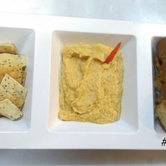A picture of Hummus with baked namken and garlic bread.