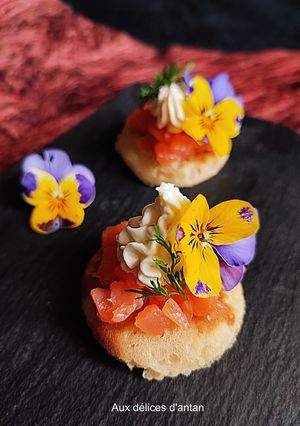 Une photo de Blini saumon fumé, chèvre et fleur de pensée