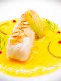 Baccalà con salsa di arancia, buccia di limone caramellata e lamelle di mandorle tostate