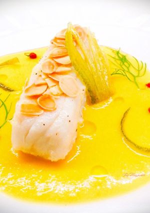 Foto di Baccalà con salsa di arancia, buccia di limone caramellata e lamelle di mandorle tostate