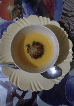 A picture of Pumpkin soup served with bread.