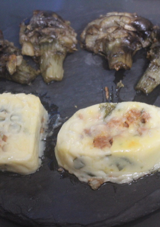 Una foto de Puré de patatas relleno y alcachofas confitadas