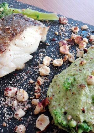 Una foto de Skrei con puré de brócoli y avellanas tostadas