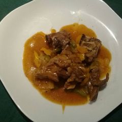 A picture of Onion beef stew and green pepper.
