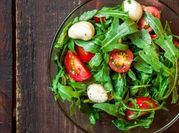Una foto de ensalada de rucula y mozzarella