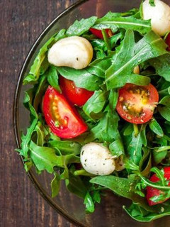 Una foto de Ensalada de tomate, mozzarella, lechugas y albahaca