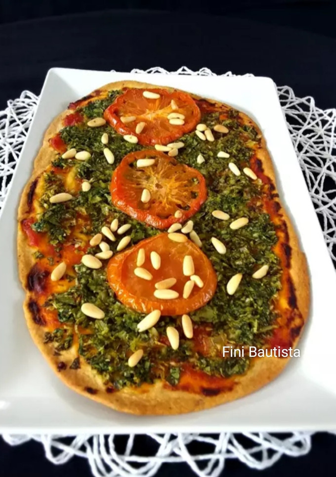 Una foto de Pizza de espinacas tomate y piñones