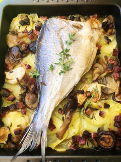 Una foto de Dorada al horno con patatas, setas y jamón