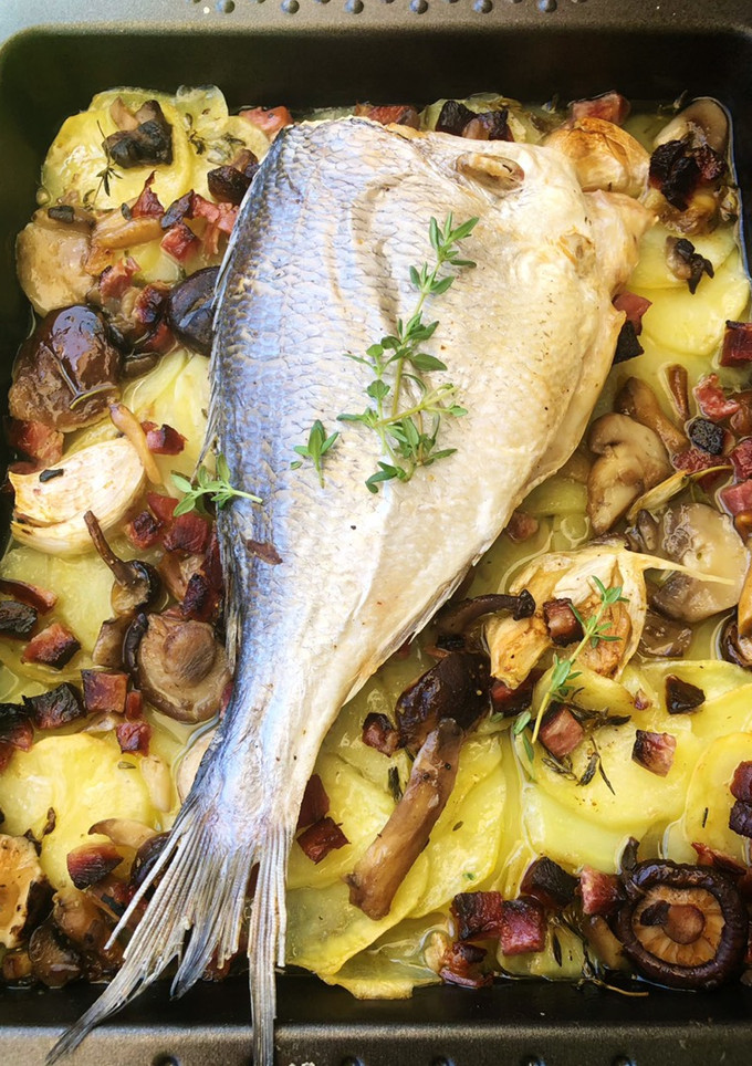 Una foto de Dorada al horno con patatas, setas y jamón