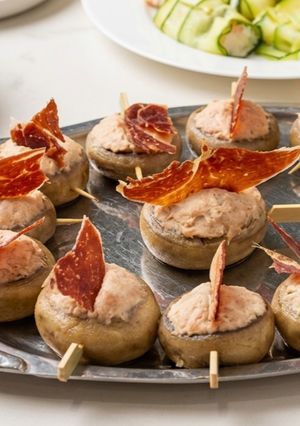 Una foto de Pintxo de Champiñon en escabeche con batida de jamón y crujiente de Paleta ibérica