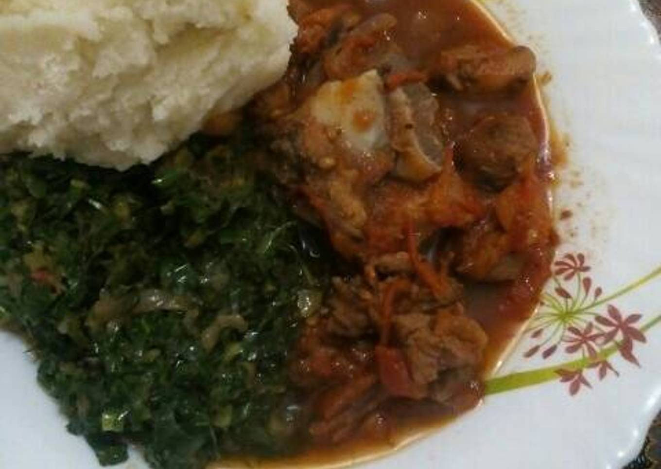 Fried Goat meat served with greens and ugali
