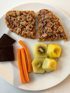 Una foto de Tostada con atún y tomate, con kiwi, zanahoria y chocolate