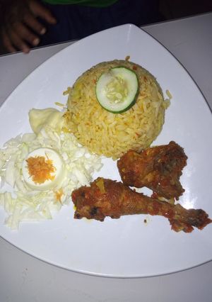 A picture of Jallof Rice and pepper chicken.