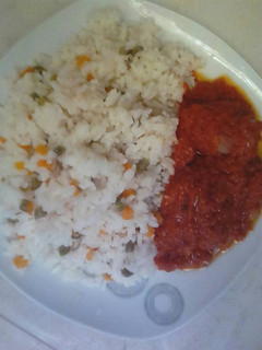 A picture of Rice with mixed vegetable with chicken stew.