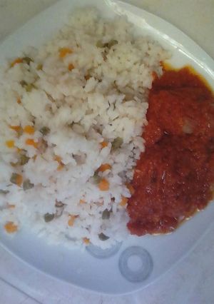 A picture of Rice with mixed vegetable with chicken stew.
