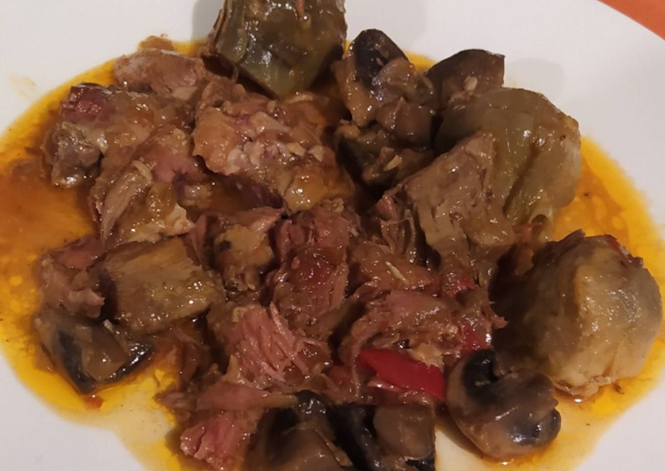 Paletilla de cordero en caldereta con alcachofas y champiñones
