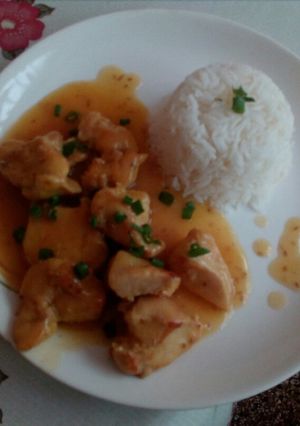 Una foto de Pollo a la naranja, con acompañamiento de arroz blanco