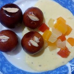 A picture of Gulab Jamun with fruit kesar rabdi.