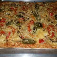 Una foto de Pizza de atún y pimientos rojos y pimientos patrón con queso