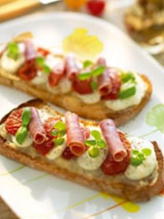 Una foto de Brusquetta de tomate confitado, jamón ibérico, mozzarella y mermelada