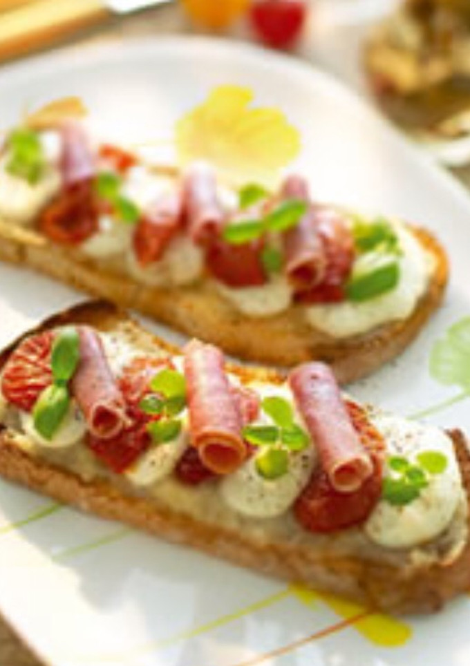 Una foto de Brusquetta de tomate confitado, jamón ibérico, mozzarella y mermelada