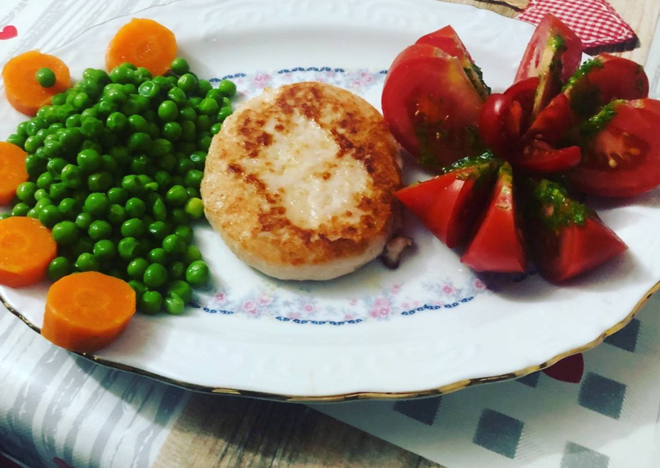Hamburguesa de pollo con flor de tomate, guisantes y zanahoria