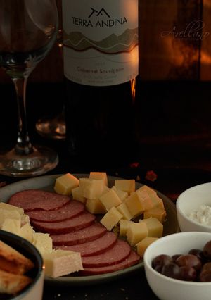 Una foto de Tabla de quesos acompañado por un rico vino chileno 🇨🇱