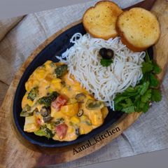 A picture of Saute veggies with cheese sauce.