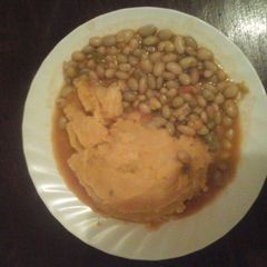 A picture of Mashed potatoes with stewed beans.