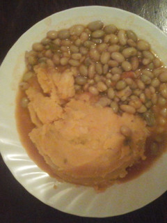A picture of Mashed potatoes with stewed beans.